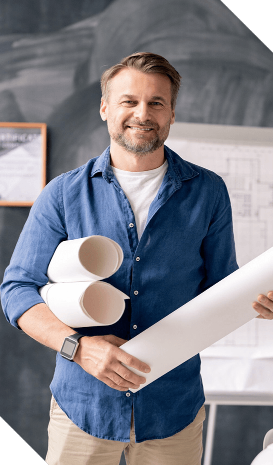 Successful mature engineer with rolled blueprints standing in front of camera